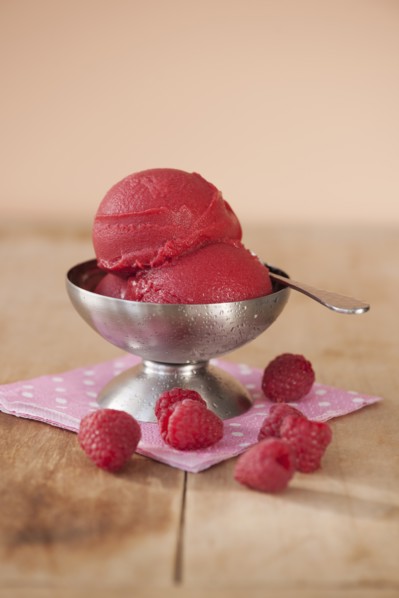 Close up of ice cream and raspberries.