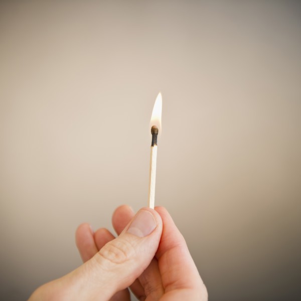 Hand holding match. Photo: Jamie Grill Photography