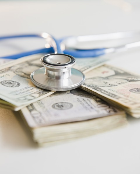 Studio shot of stethoscope on banknotes. Photo: Jamie Grill Photography