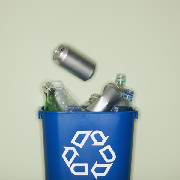 Close up of bottles and cans in recycle container.