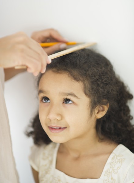 Mother measuring daughter (6-7).