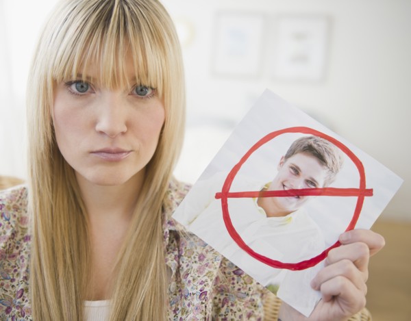 Young woman holding photograph of ex-boyfriend. Photo: Jamie Grill Photography