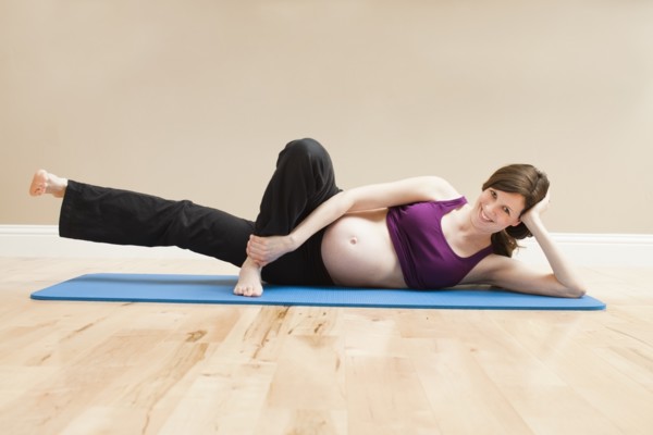 Young pregnant woman exercising. Photo : Mike Kemp