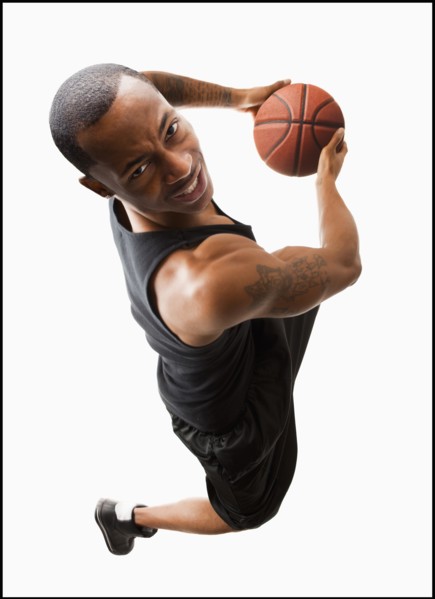 Studio shot of young man playing basketball. Photo : Mike Kemp