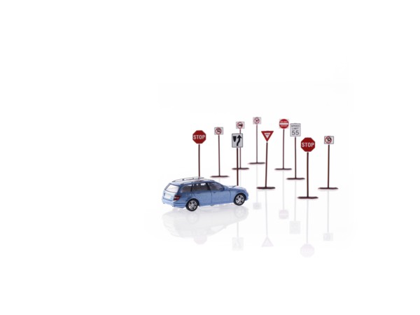 Studio shot of toy road signs and car. Photo : David Arky