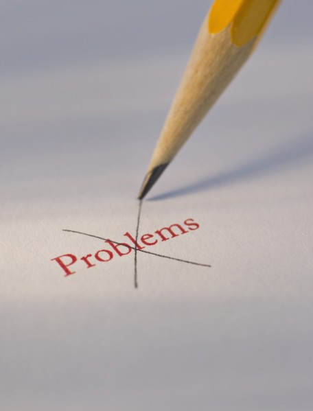 Studio shot of pencil crossing out the word problems from piece of paper. Photo : Daniel Grill