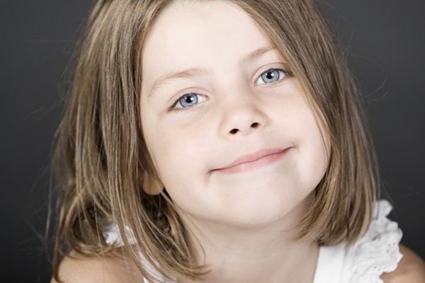 Studio portrait of smiling girl (6-7). Photo : Justin Paget