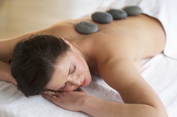 Woman receiving hot stone therapy.