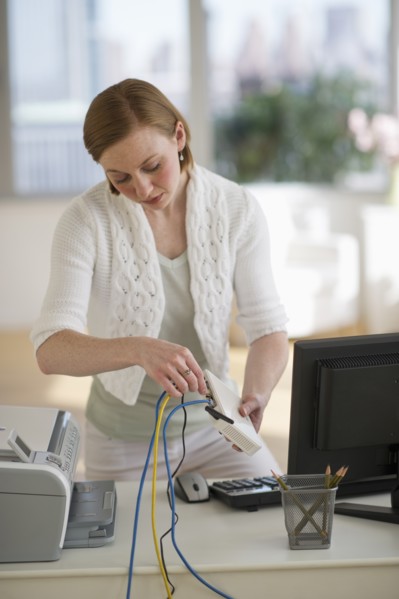 Woman installing router at home office.