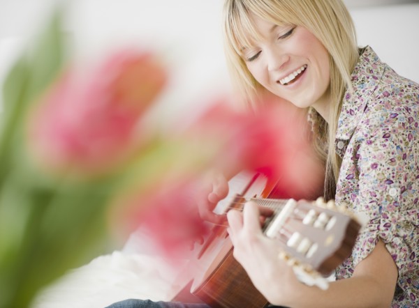 Young woman playing guitar. Photo : Jamie Grill Photography