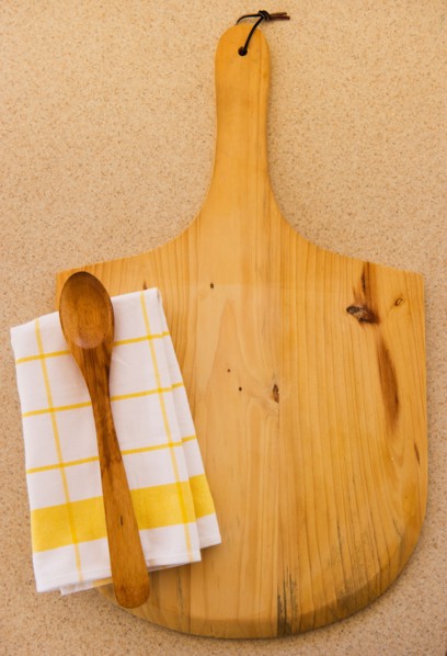 Wooden chopping board, spoon ad checked napkin. Photo : Daniel Grill