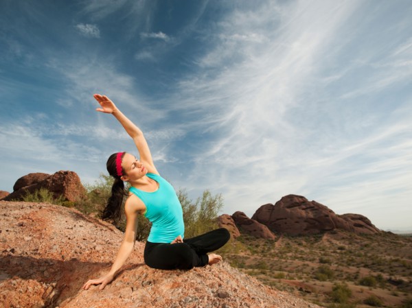 USA, Arizona, Phoenix, Young woman practicing yoga on desert.