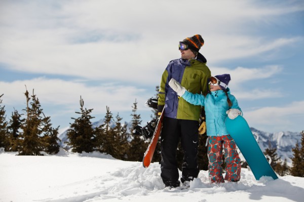 USA, Colorado, Telluride, Father and daughter (10-11) standing with snowboards in winter scenery.