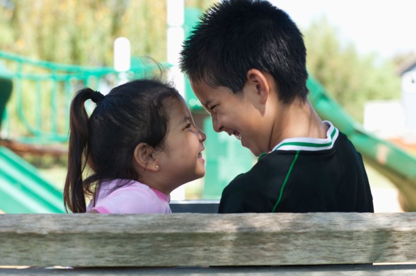 Brother and sister (4-13) face to face at playground. Photo : Noah Clayton