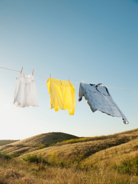 Laundry hanging on clothesline against blue sky.