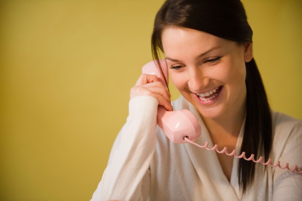 Smiling young woman talking on phone. Photo : Jamie Grill Photography