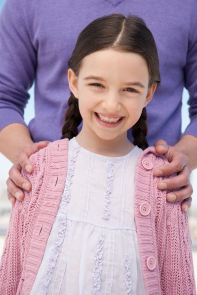Portrait daughter (8-9) embraced by father.