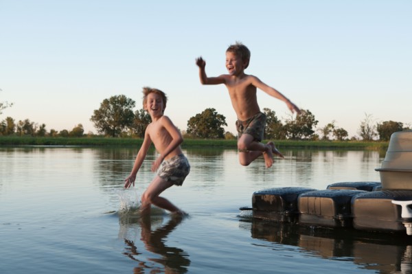 USA, Texas, Texarkana, Two boys (8-9) jumping into lake. Photo : King Lawrence