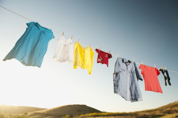 Laundry hanging on clothesline against blue sky.