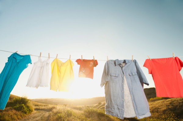 Laundry hanging on clothesline against blue sky.