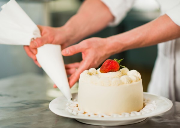 Pastry chef decorating cake.
