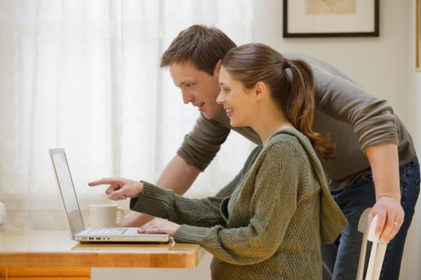 Couple using laptop at home. Photo : Rob Lewine