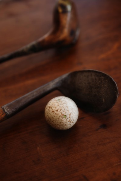 Close up of antique golf clubs and golf ball.