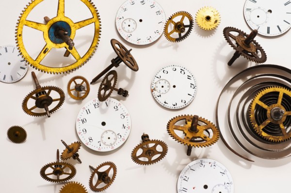 Close up of gears and clock parts on white background.