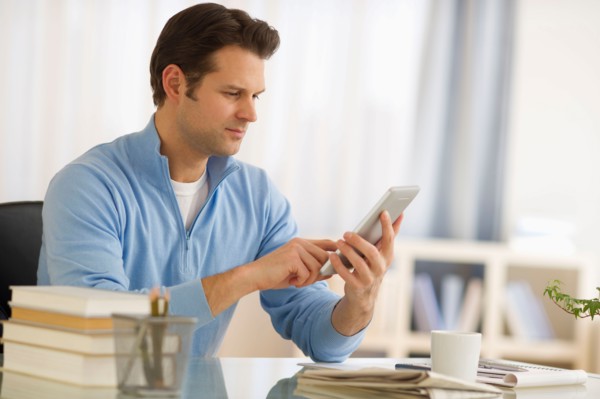 Man using digital tablet at home office.