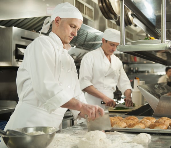 Chef cutting pastry to make rolls.