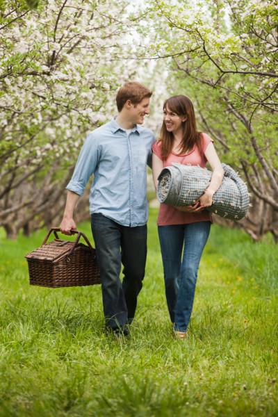 USA, Utah, Provo, Young couple with picnic basket in orchard. Photo : Mike Kemp