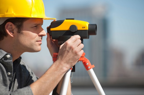 Surveyor using theodolite.