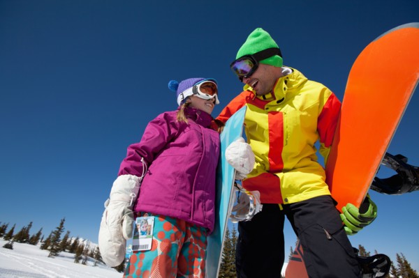 USA, Colorado, Telluride, Father and daughter (10-11) posing with snowboards in winter scenery.