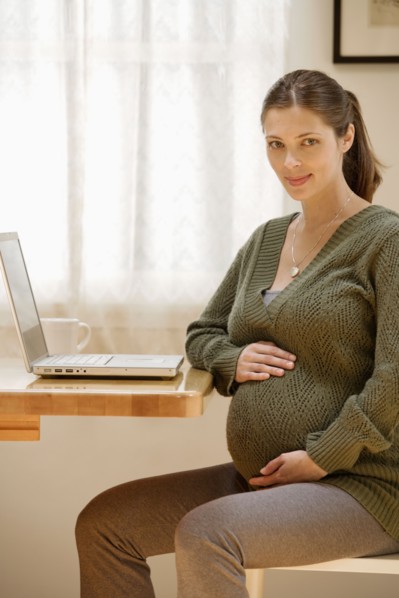 Portrait of expecting mother with laptop. Photo : Rob Lewine