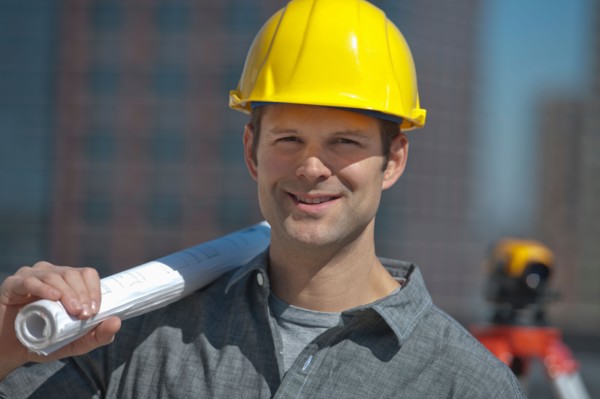 Portrait of worker holding blueprint.
