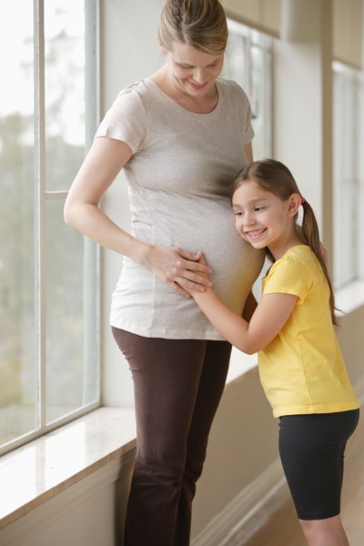 Pregnant woman with daughter (6-7). Photo : Rob Lewine