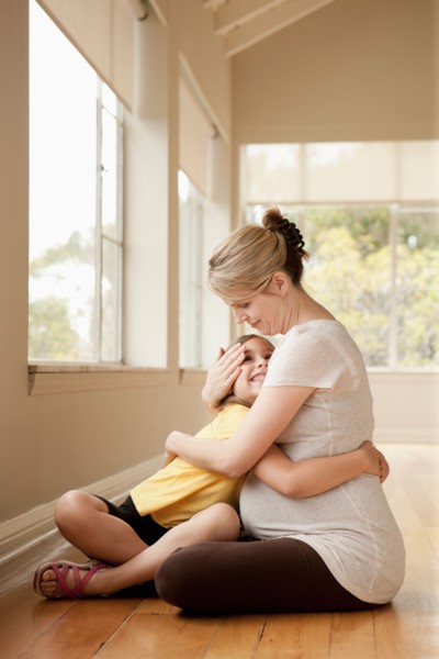 Daughter embracing (6-7) pregnant mother. Photo : Rob Lewine
