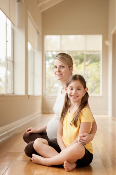 Pregnant mother and daughter (6-7)practicing yoga. Photo : Rob Lewine