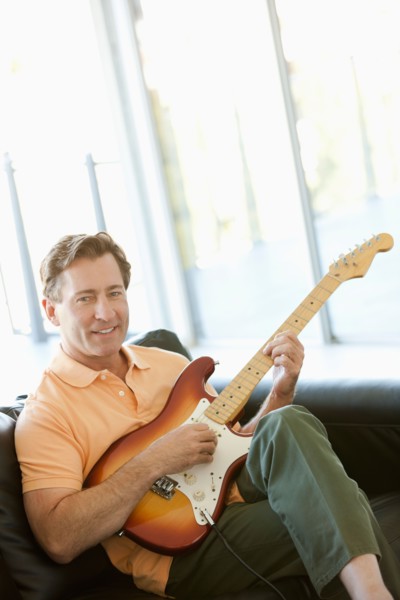 Mature man playing guitar. Photo : Rob Lewine