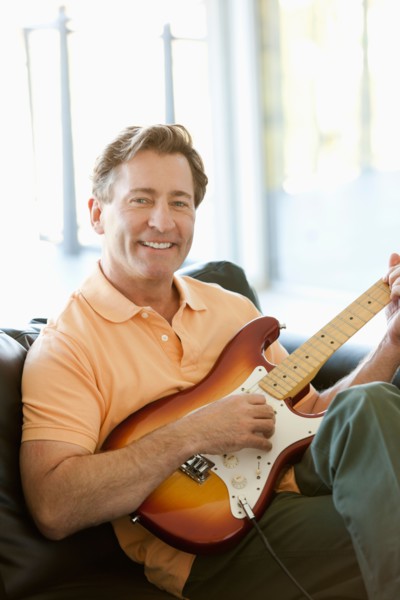 Mature man playing guitar. Photo : Rob Lewine