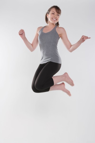 Portrait of young woman jumping, studio shot. Photo : Rob Lewine