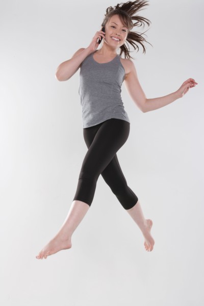 Portrait of young woman jumping, studio shot. Photo : Rob Lewine