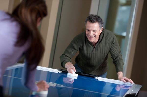 Couple playing air hockey. Photo: db2stock