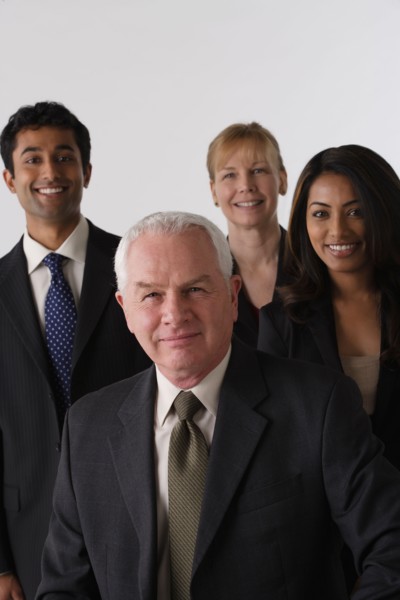 Portrait of four business people, studio shot. Photo : Rob Lewine