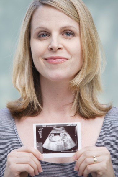 Pregnant woman holding CAT image of her belly. Photo : Rob Lewine