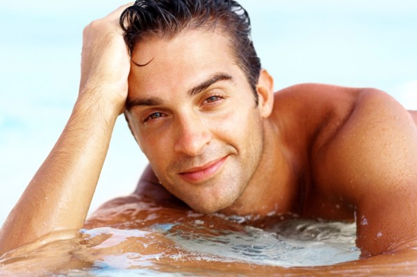 Portrait of attractive young man relaxing on beach. Photo : momentimages