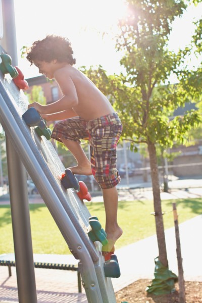 USA, New York State, New York City, Brooklyn, Boy (6-7) climbing up jungle gym. Photo: Johannes