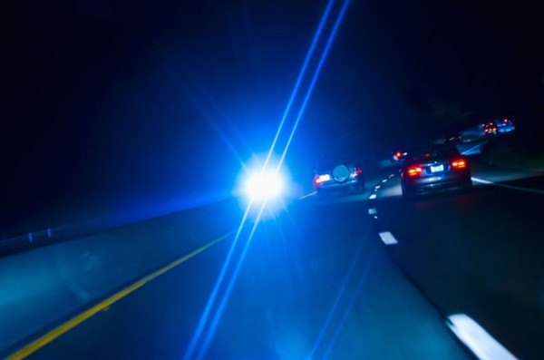 Car headlights on road at night.