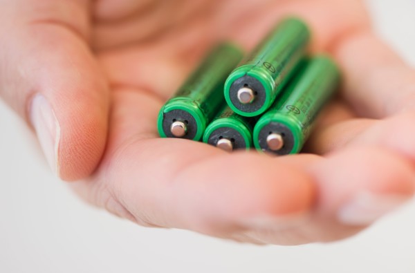 Hand holding batteries.