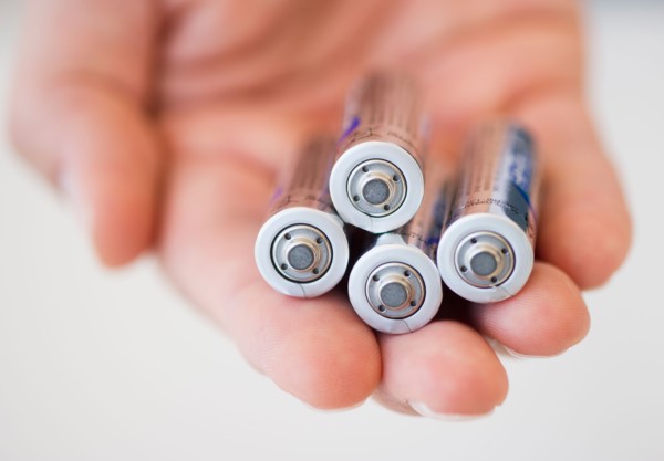 Hand holding batteries.